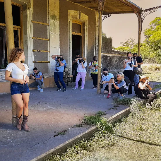 Clase de fotografía en el exterior, modelo posando y estudiantes tomando fotos